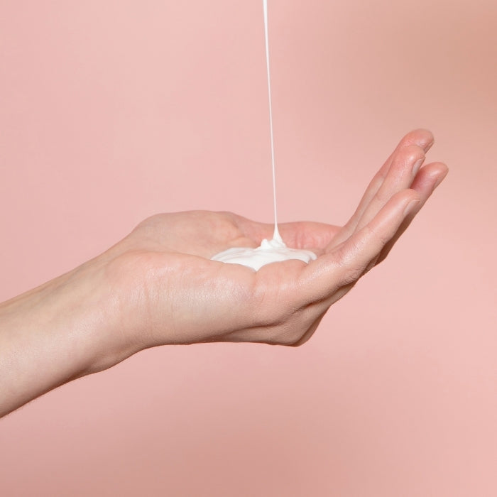 Une main qui reçoit du lait corps ultra-hydratant conçu pour hydrater la peau