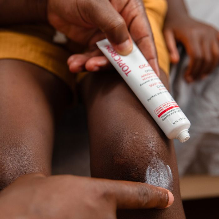 PARENTS-QUI-APPLIQUE-CREME-CICATRISANTE-SUR-GENOU-DUN-ENFANT