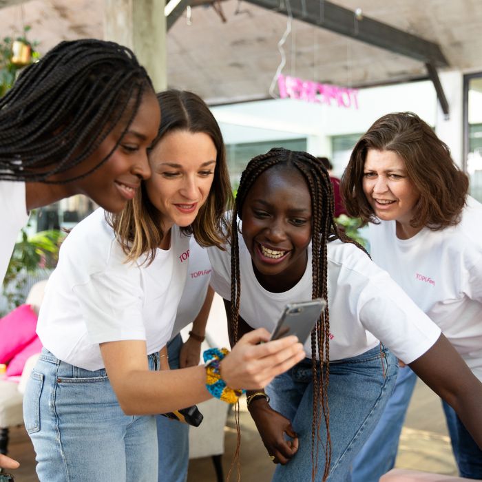 PLUSIEURS-FEMMES-REGARDENT-UN-TELEPHONE