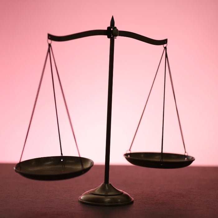 UNE-BALANCE-DE-JUSTICE-SUR-FOND-ROSE